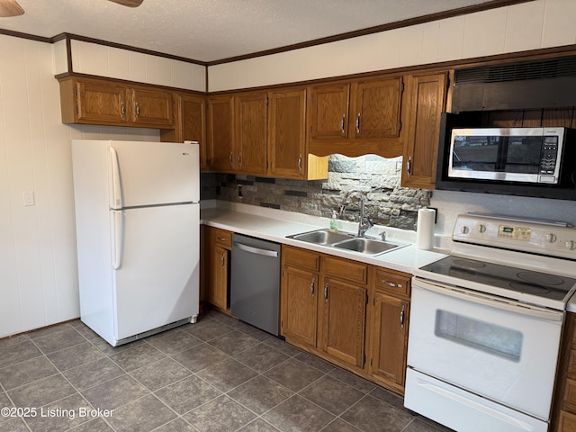 kitchen with appliances with stainless steel finishes, sink, backsplash, ornamental molding, and a textured ceiling