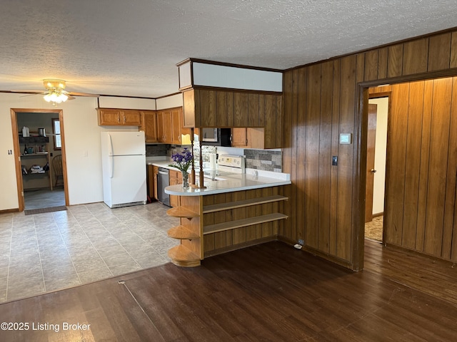 kitchen with white refrigerator, dishwasher, light wood-type flooring, and kitchen peninsula