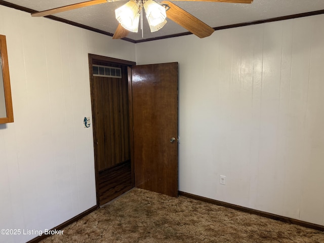 unfurnished bedroom featuring crown molding, a textured ceiling, carpet floors, beamed ceiling, and ceiling fan