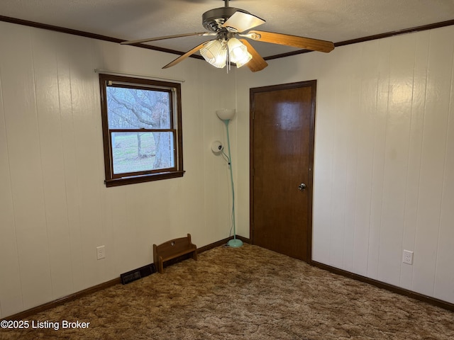 unfurnished room featuring crown molding, carpet flooring, and ceiling fan