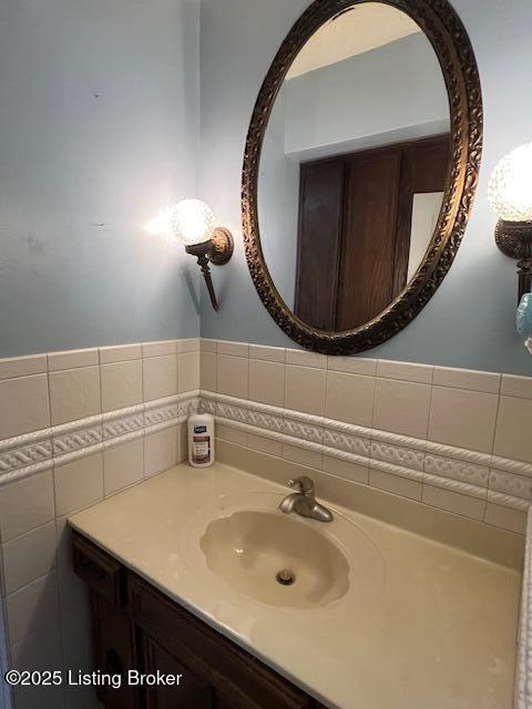 bathroom featuring vanity and tile walls