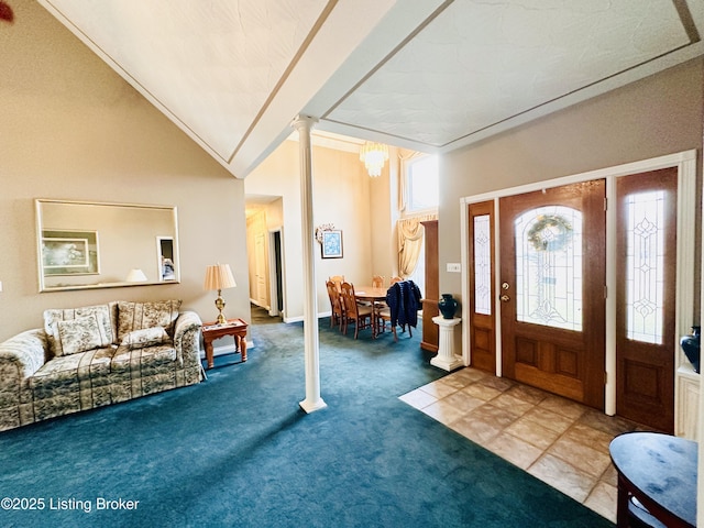 carpeted foyer entrance featuring ornate columns and vaulted ceiling