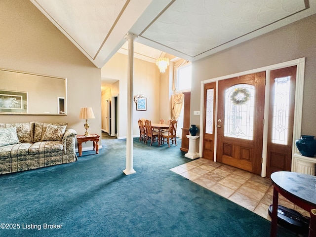 carpeted entrance foyer with ornate columns and vaulted ceiling