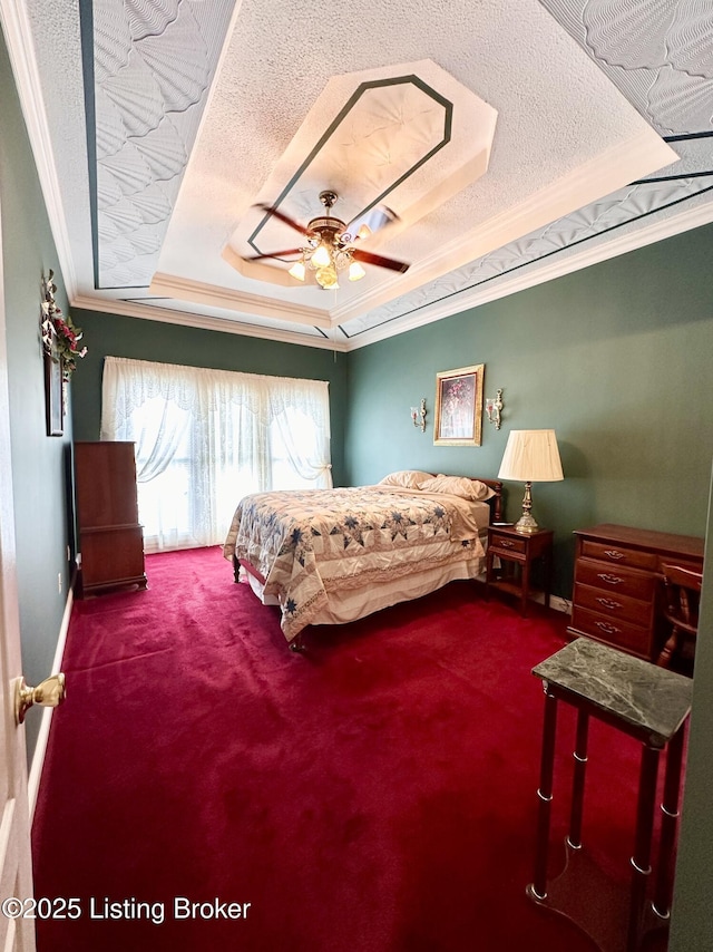 carpeted bedroom with crown molding, ceiling fan, a raised ceiling, and a textured ceiling