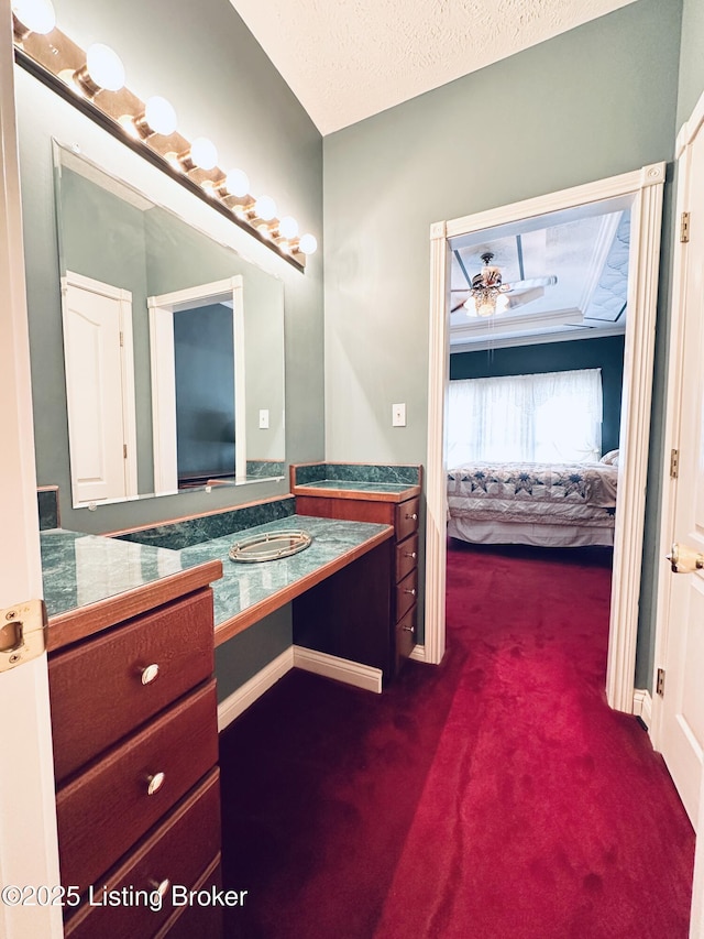 bathroom with ceiling fan, vanity, and a textured ceiling