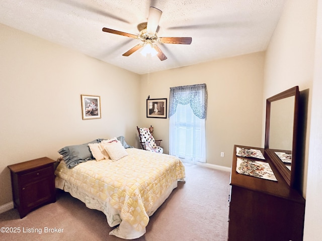 carpeted bedroom featuring ceiling fan and a textured ceiling