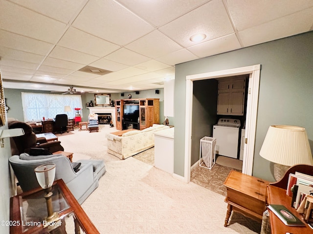 living room featuring washer / clothes dryer, carpet floors, and a drop ceiling