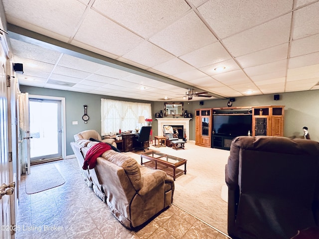 living room featuring a drop ceiling and ceiling fan