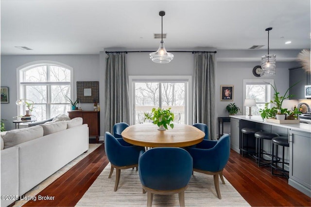 dining space with dark wood-type flooring and a healthy amount of sunlight