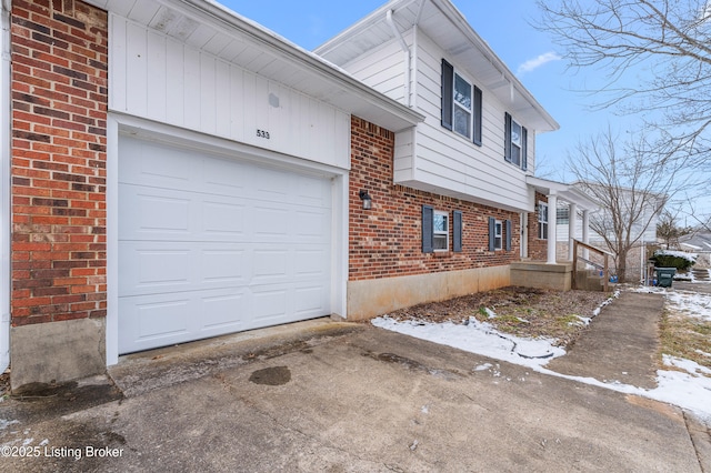 view of side of property with brick siding, an attached garage, and driveway