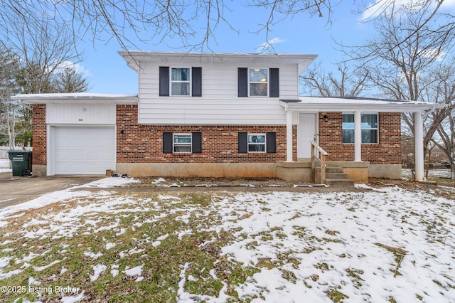 split level home featuring a garage, brick siding, and driveway