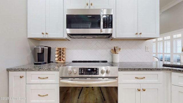 kitchen with tasteful backsplash, appliances with stainless steel finishes, and white cabinets