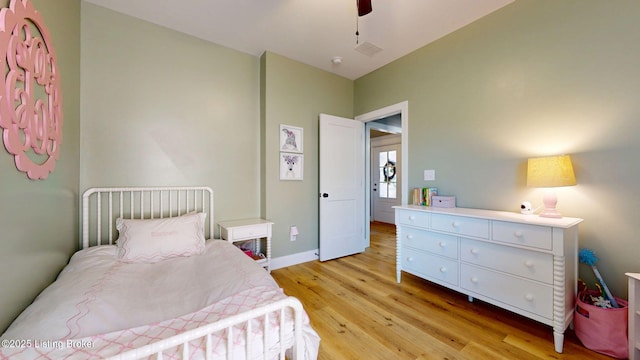 bedroom with visible vents, light wood-type flooring, a ceiling fan, and baseboards