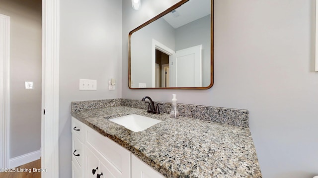 bathroom featuring baseboards, wood finished floors, and vanity