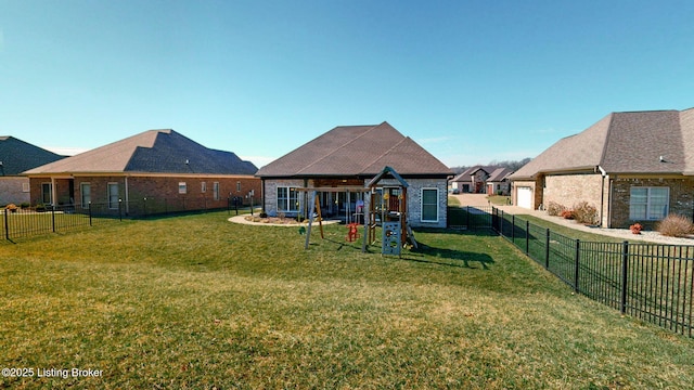 rear view of property featuring a playground, a lawn, and a fenced backyard