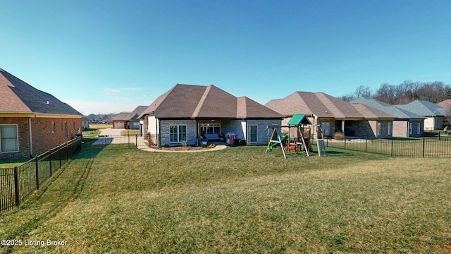 rear view of property with a fenced backyard, a playground, and a yard