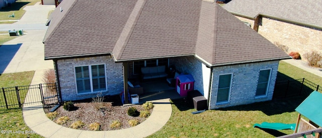 back of house featuring a fenced backyard, a lawn, and brick siding