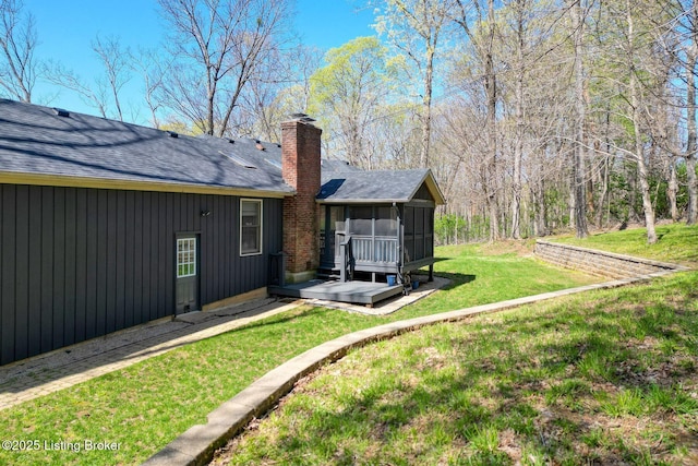 13200 Creekview Rd, Prospect, KY 40059 - rear view of property featuring roof with shingles, a chimney, a wooden deck, a sunroom, and a lawn