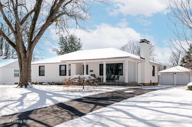 view of front of home with a garage, a porch, and an outdoor structure