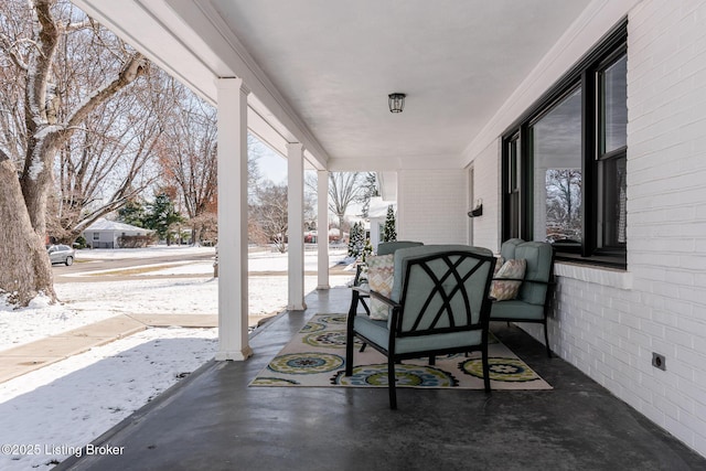 snow covered patio featuring a porch