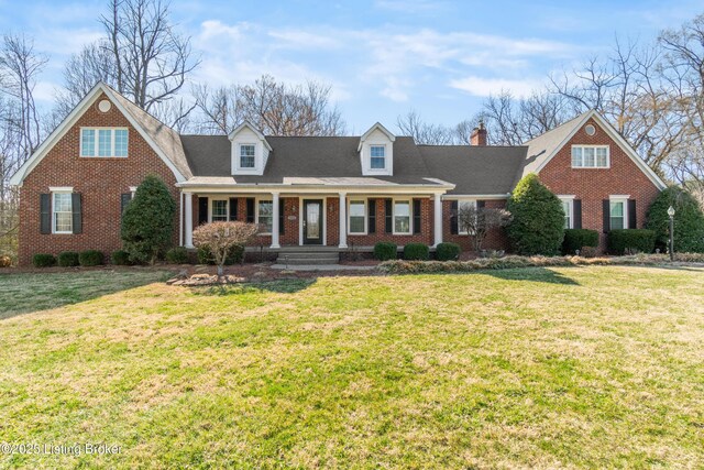 new england style home with brick siding, roof with shingles, and a front yard