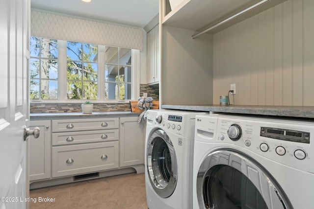 washroom featuring visible vents, separate washer and dryer, light tile patterned floors, and cabinet space