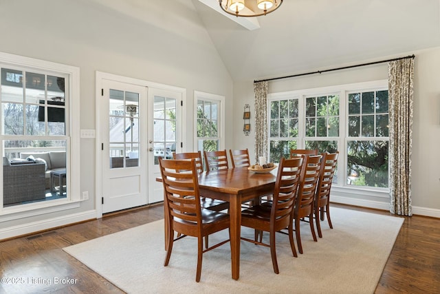 dining room featuring vaulted ceiling, plenty of natural light, dark wood-style floors, and visible vents