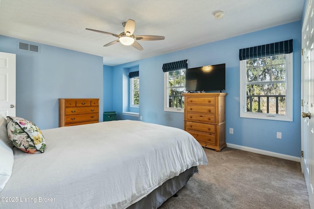 carpeted bedroom with a ceiling fan, visible vents, and baseboards