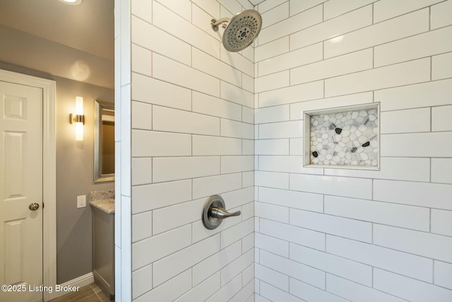 bathroom with baseboards and a tile shower