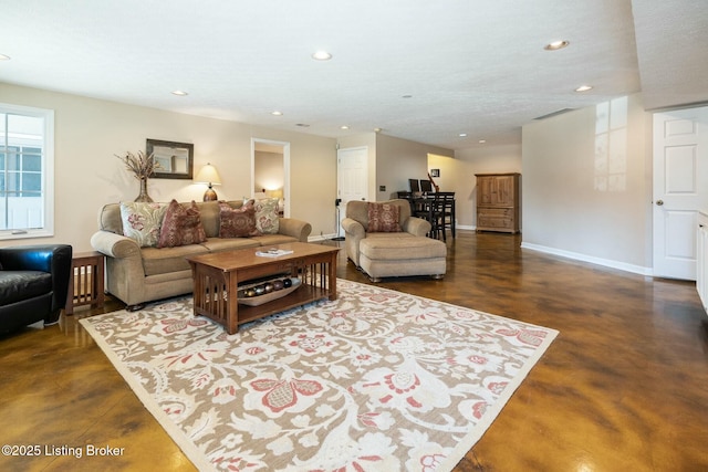 living area featuring finished concrete floors, baseboards, and recessed lighting