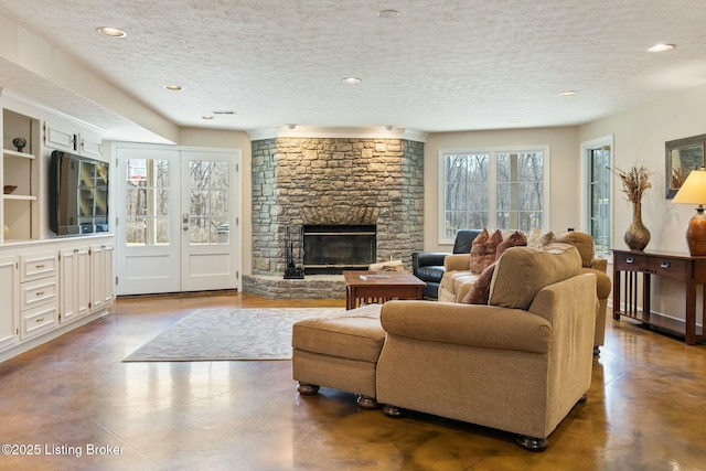 living area with a textured ceiling, recessed lighting, concrete floors, a fireplace, and french doors