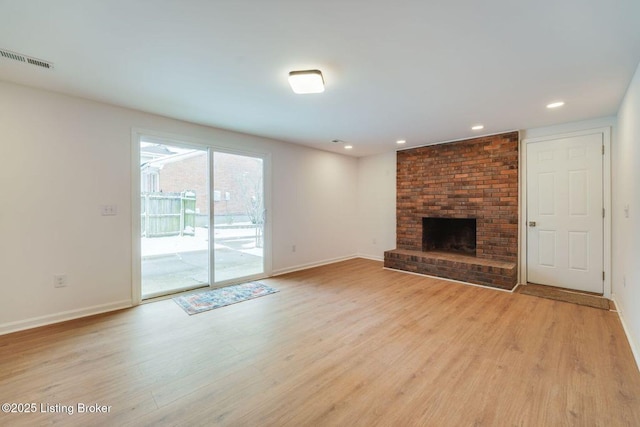 unfurnished living room featuring a fireplace, light wood finished floors, recessed lighting, visible vents, and baseboards