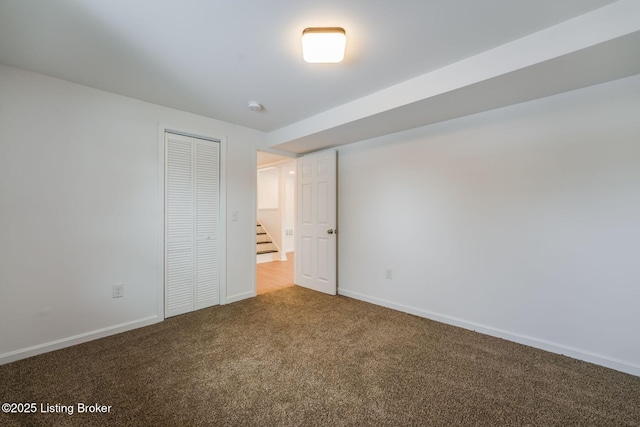 unfurnished bedroom with carpet floors, a closet, and baseboards