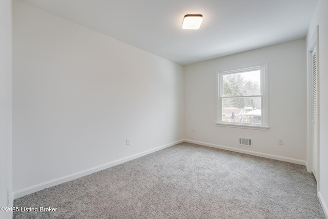 unfurnished room featuring carpet, visible vents, and baseboards