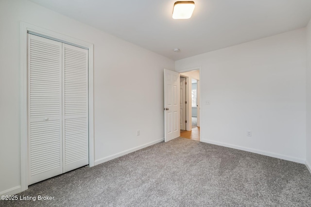 unfurnished bedroom featuring a closet, carpet flooring, and baseboards