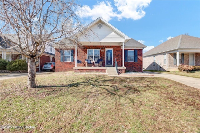 view of front of home featuring covered porch, driveway, brick siding, and a front lawn