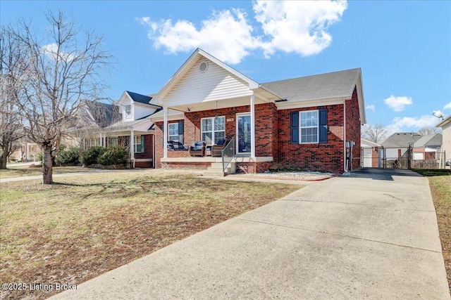 view of front of property with brick siding, a porch, fence, and a front yard