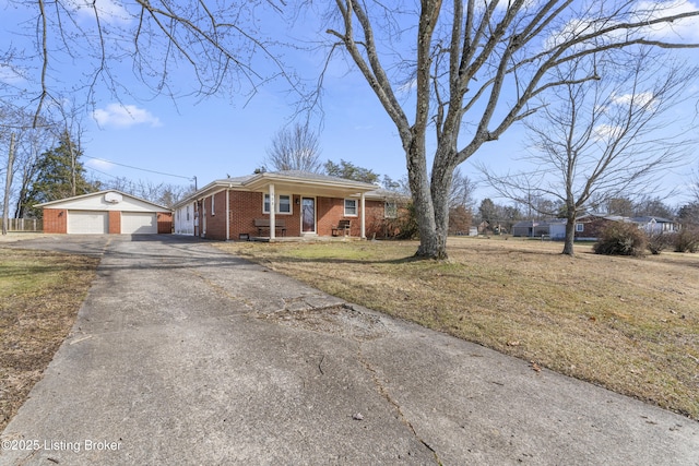 single story home with a garage, a front yard, an outbuilding, and covered porch