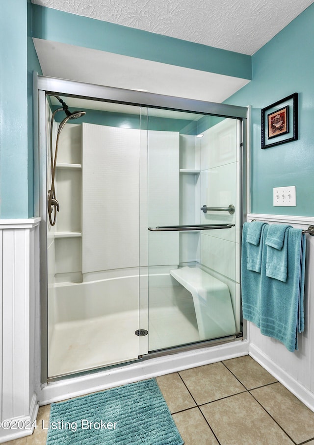 bathroom featuring tile patterned flooring, a textured ceiling, and walk in shower