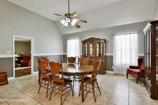 dining area with light tile patterned flooring, ceiling fan, and high vaulted ceiling