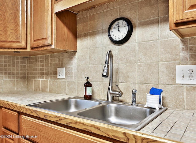 kitchen with sink, tile counters, and decorative backsplash