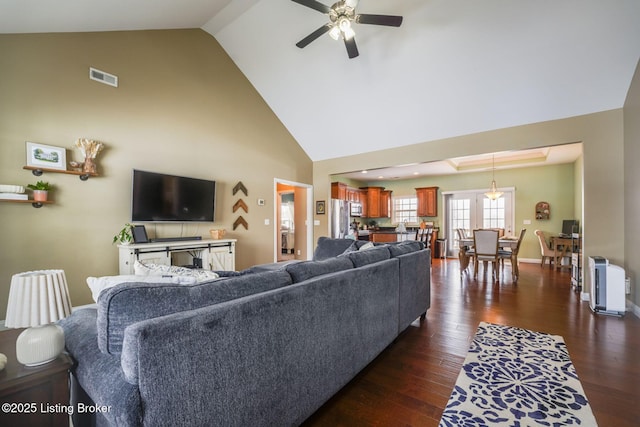 living room with ceiling fan, high vaulted ceiling, and dark hardwood / wood-style floors