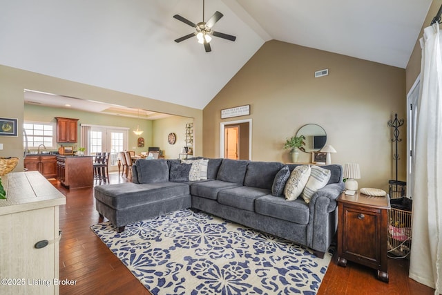 living room with ceiling fan, high vaulted ceiling, dark wood-type flooring, and sink