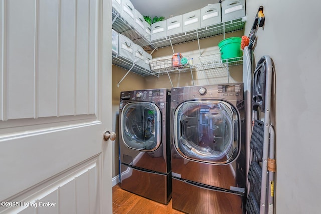 laundry area with washing machine and dryer and light hardwood / wood-style floors