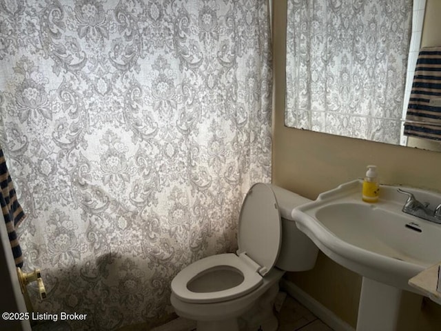 bathroom with tile patterned flooring, shower / bath combination with curtain, and toilet