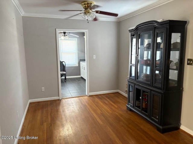 unfurnished dining area with crown molding, dark wood-type flooring, and ceiling fan