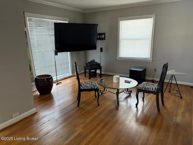 living area featuring hardwood / wood-style flooring and ornamental molding