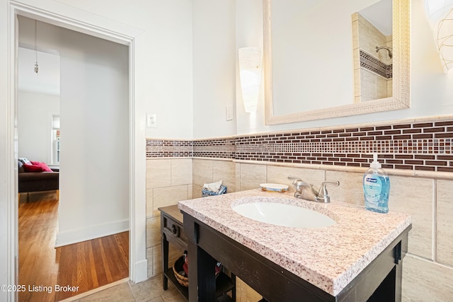 bathroom featuring hardwood / wood-style floors, vanity, and tile walls