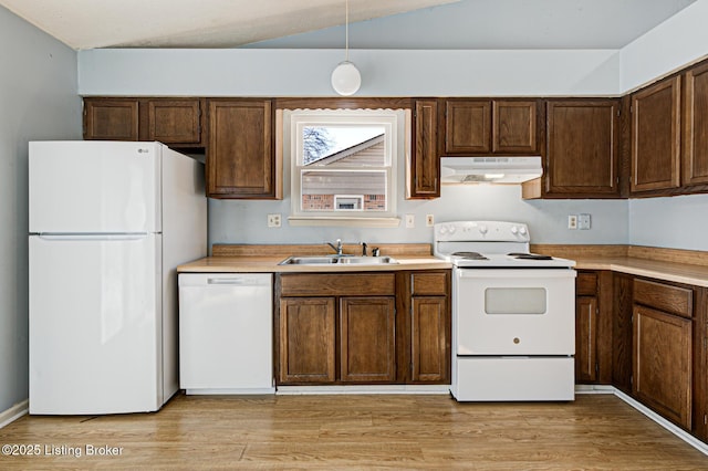 kitchen with white appliances, decorative light fixtures, light hardwood / wood-style floors, vaulted ceiling, and sink