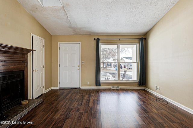 unfurnished living room with dark wood-type flooring and a textured ceiling